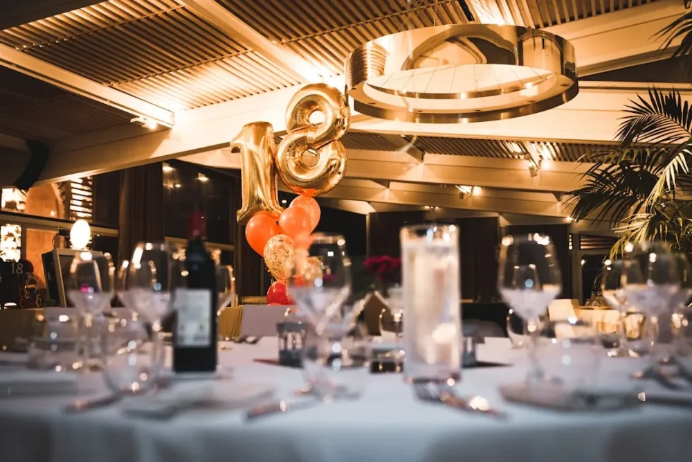 Table setting with balloons in the background for an 18th birthday celebration with party entertainment