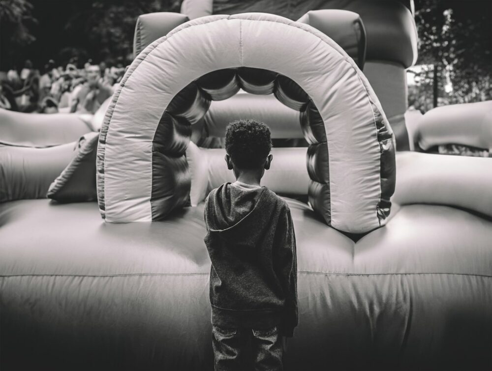 A boy excited to jump on a bounce house rental with his friends for his birthday party