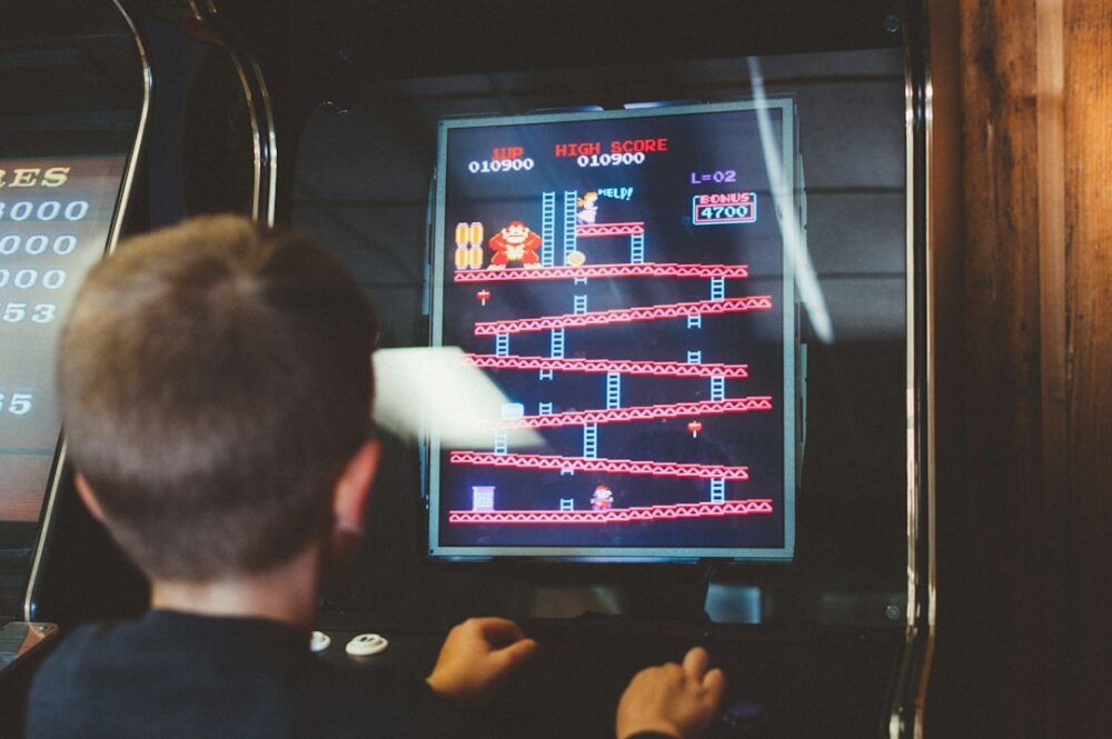 A young boy playing the Donkey Kong arcade game at a kids' birthday party.