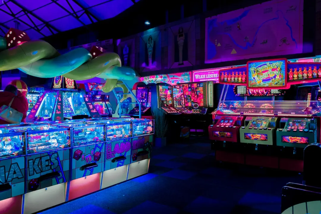 Backlit arcade games at a dark indoor arcade party event venue.
