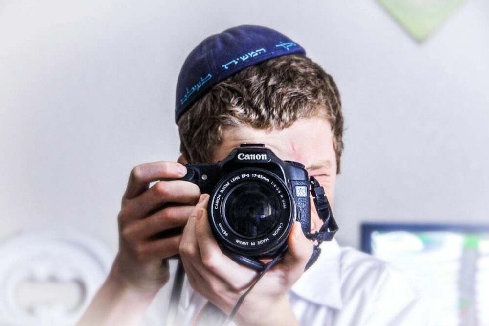 A young man taking photos at his coming-of-age Bar Mitzvah party