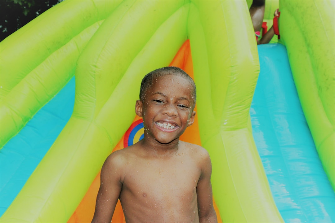 A child enjoying their time on an inflatable water slide.